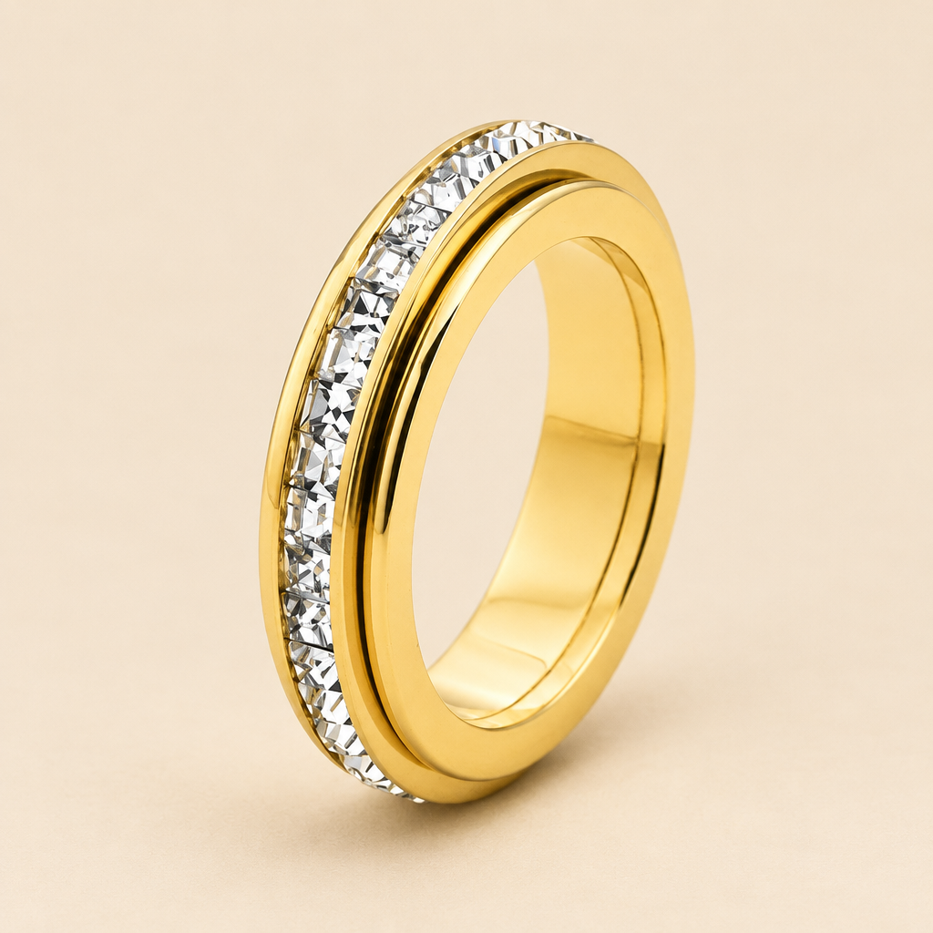 Anello dorato con fila di dettagli luminosi su fondo beige chiaro